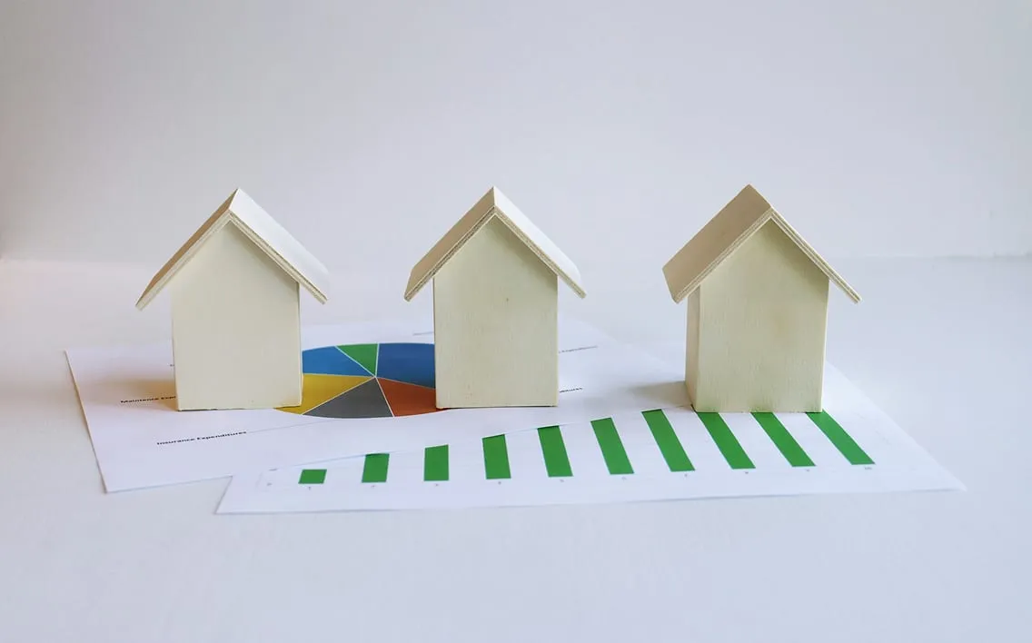 Miniaturas de casas sobre gráficos de consumo energético