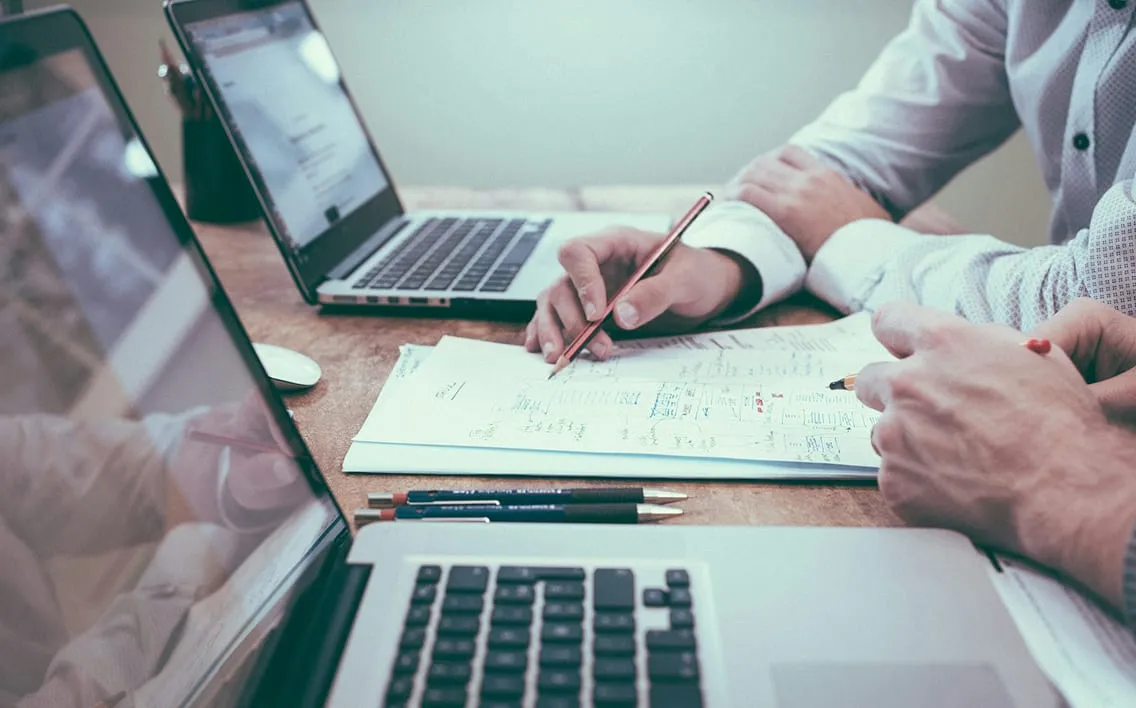 Pessoas analisando documentos e gráficos financeiros